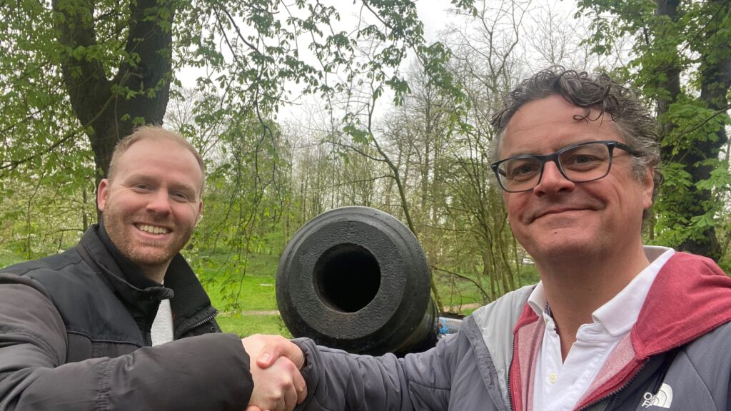 Rens en Jelle schudden elkaar de hand voor een kanon